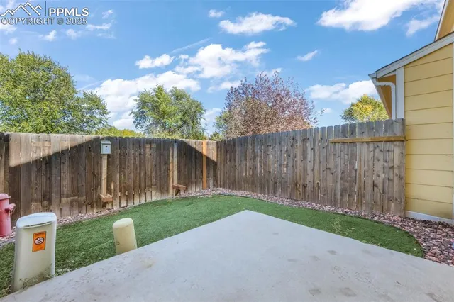 a view of backyard with wooden fence
