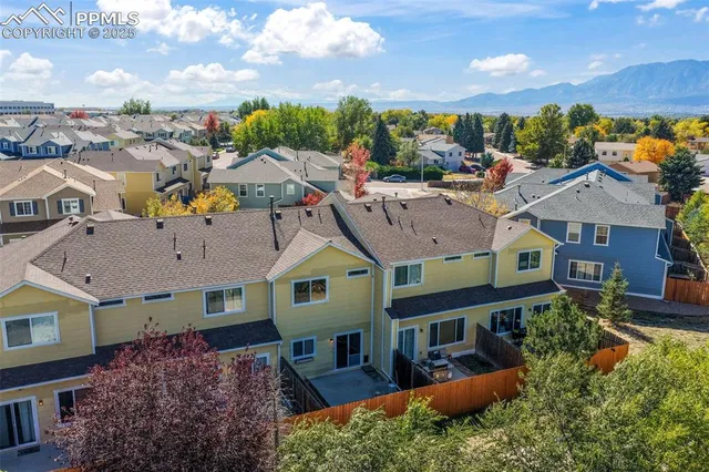 an aerial view of multiple houses with a yard