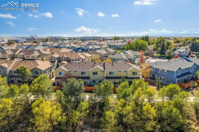 an aerial view of residential houses with outdoor space and trees