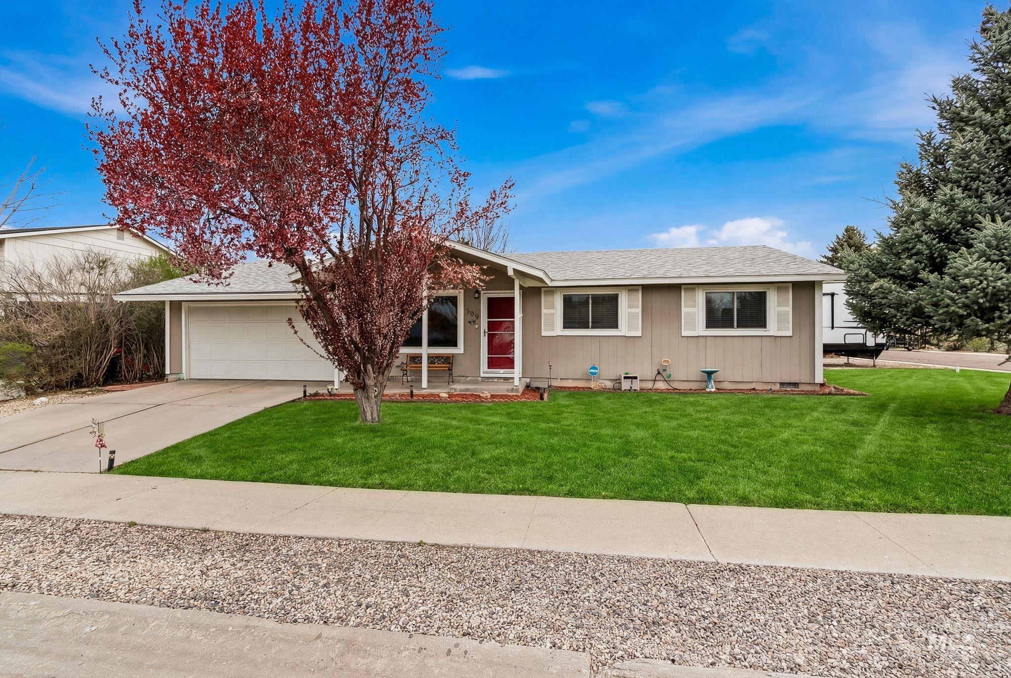 Ranch-style home featuring roof with shingles, driveway, a garage, and a front lawn