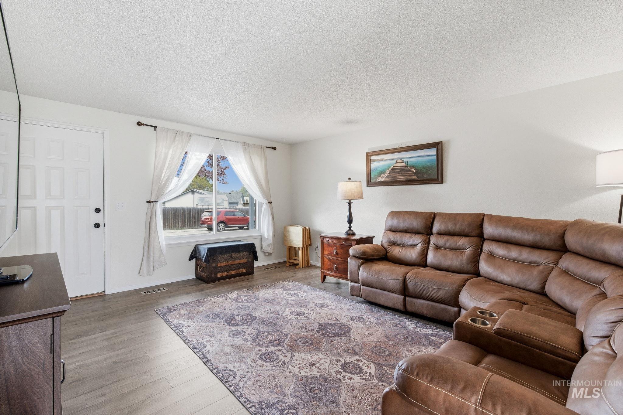 598 Easy Street Kuna, ID 83634 - Photo 11 of 50 Living room with a textured ceiling and wood finished floors