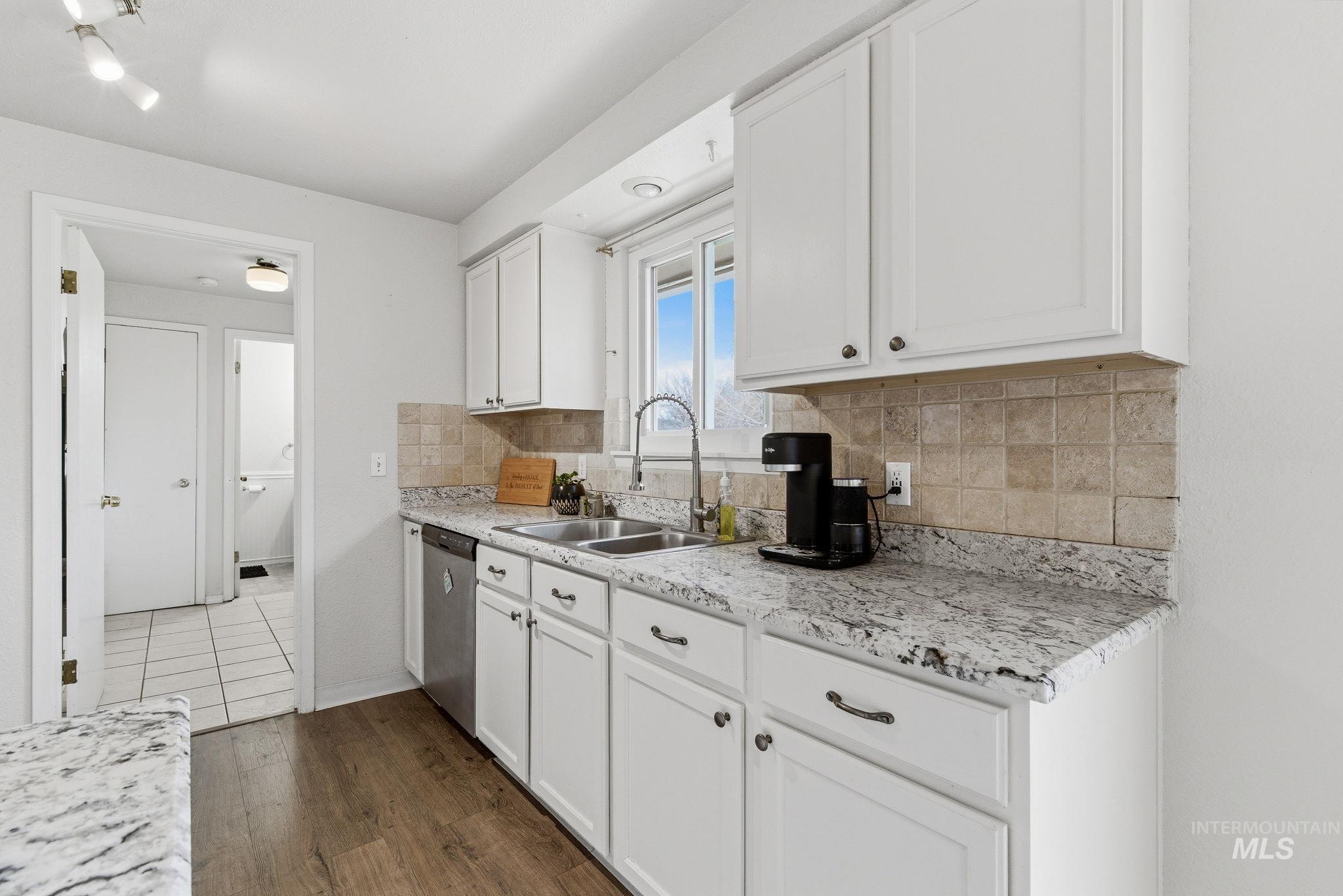 598 Easy Street Kuna, ID 83634 - Photo 15 of 50 Kitchen featuring white cabinetry, tasteful backsplash, dark wood-style flooring, and stainless steel dishwasher