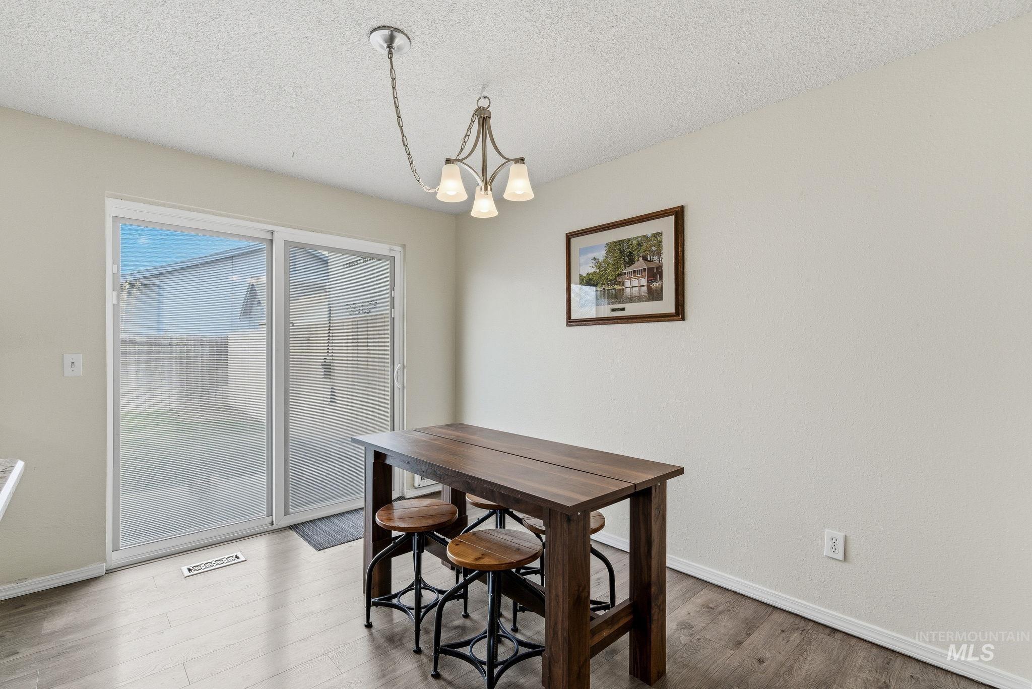 598 Easy Street Kuna, ID 83634 - Photo 23 of 50 Dining room with suspended lighting, wood finished floors, and a textured ceiling