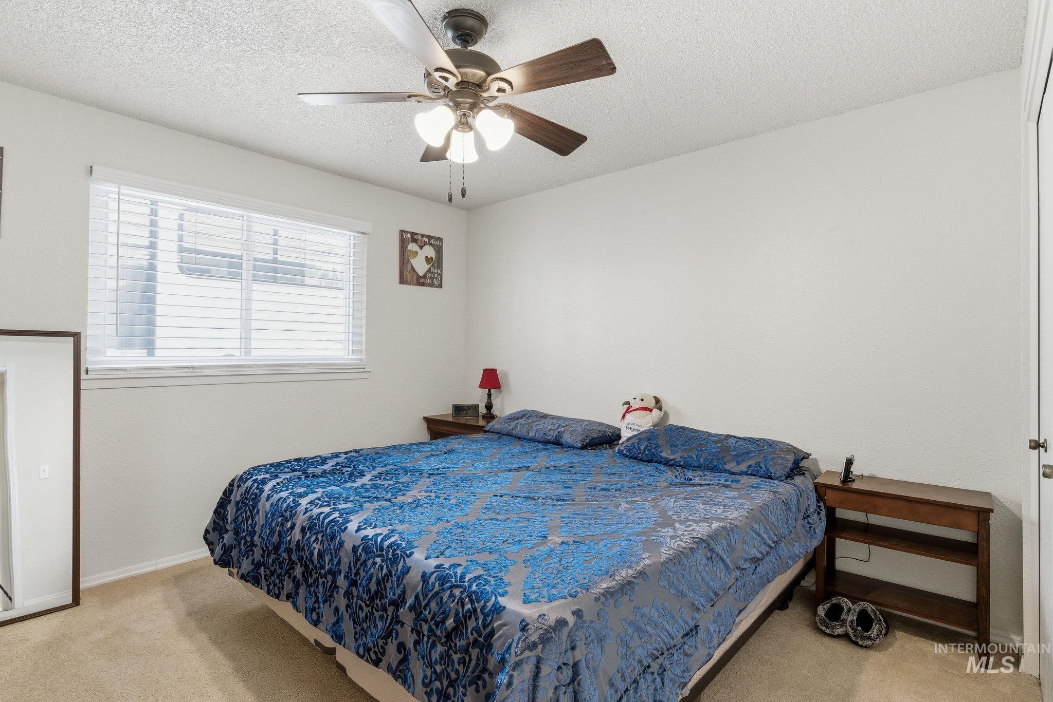 598 Easy Street Kuna, ID 83634 - Photo 26 of 50 Bedroom with light carpet, a textured ceiling, and a ceiling fan