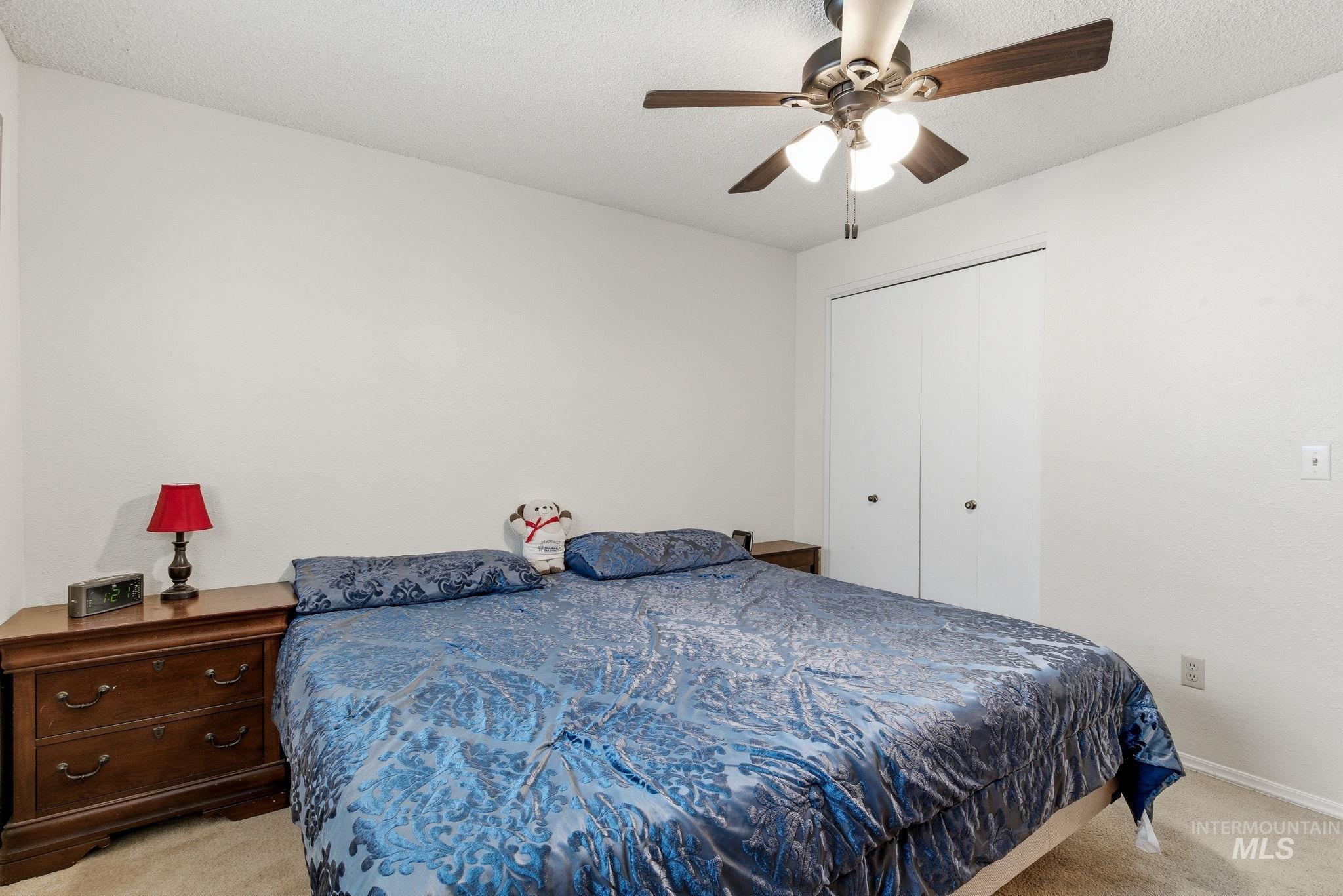 598 Easy Street Kuna, ID 83634 - Photo 27 of 50 Bedroom with light colored carpet, a closet, ceiling fan, and a textured ceiling