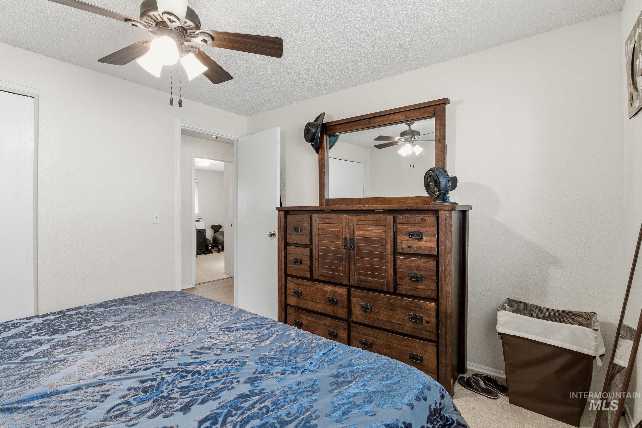 598 Easy Street Kuna, ID 83634 - Photo 28 of 50 Bedroom featuring a textured ceiling, a ceiling fan, light colored carpet, and a closet