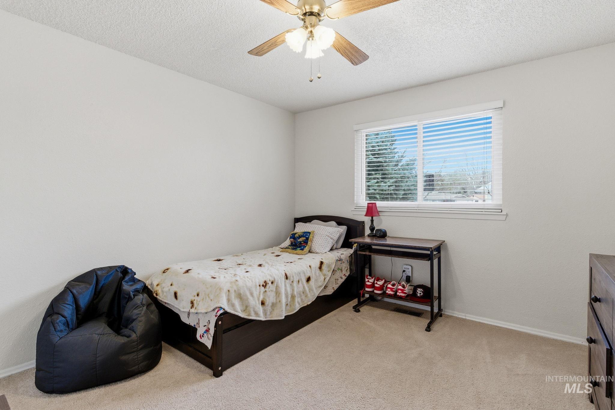 598 Easy Street Kuna, ID 83634 - Photo 29 of 50 Bedroom with light carpet, a textured ceiling, and ceiling fan