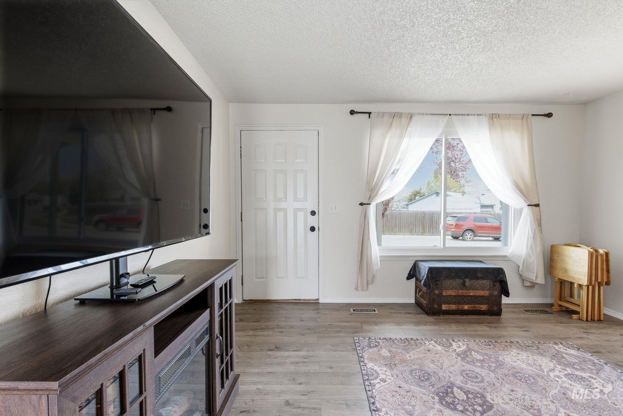 598 Easy Street Kuna, ID 83634 - Photo 7 of 50 Living room with light wood finished floors and a textured ceiling