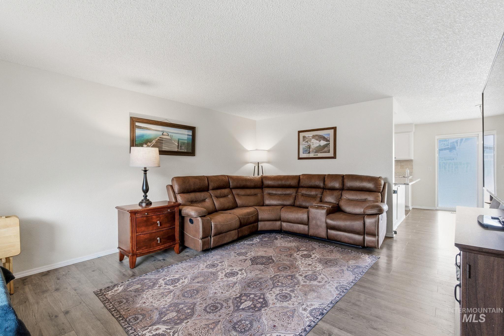 598 Easy Street Kuna, ID 83634 - Photo 8 of 50 Living area featuring wood finished floors and a textured ceiling