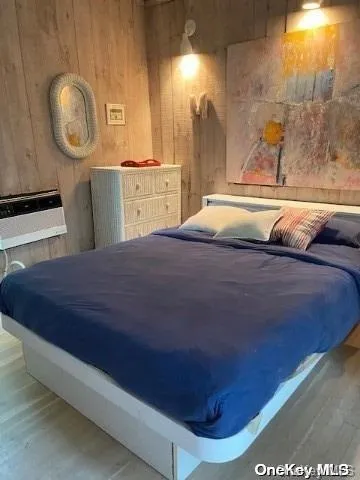 a bedroom with a bed and a lamp on dresser