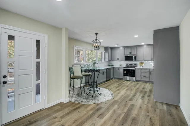 a kitchen with kitchen island a counter top space a sink stainless steel appliances and cabinets