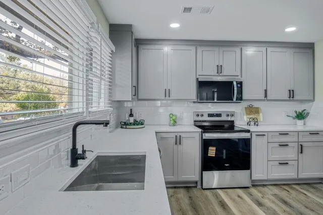 a kitchen with stainless steel appliances a stove sink and cabinets