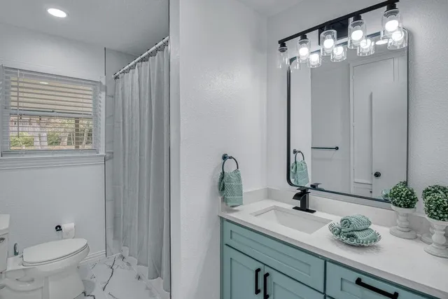 a bathroom with a toilet sink and mirror