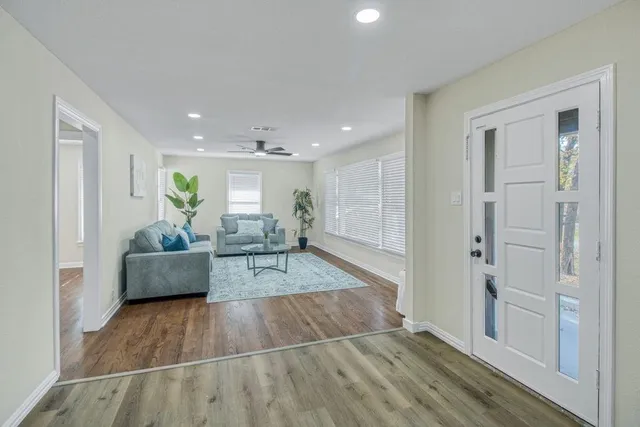 a living room with furniture and wooden floor