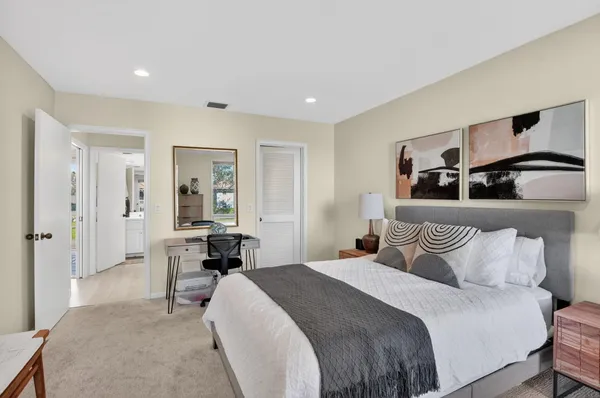 a spacious bedroom with a bed and a cabinets