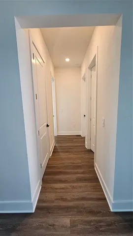 a view of a hallway with wooden floor and staircase