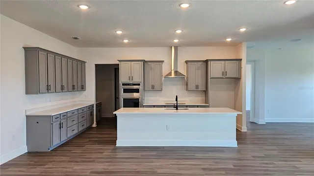 a large kitchen with stainless steel appliances kitchen island a large counter top and a stove top oven