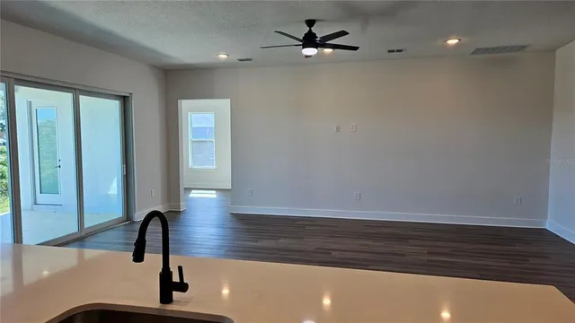 a view of room with wooden floor and ceiling fan