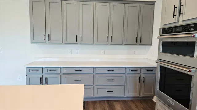 a kitchen with granite countertop white cabinets and stainless steel appliances