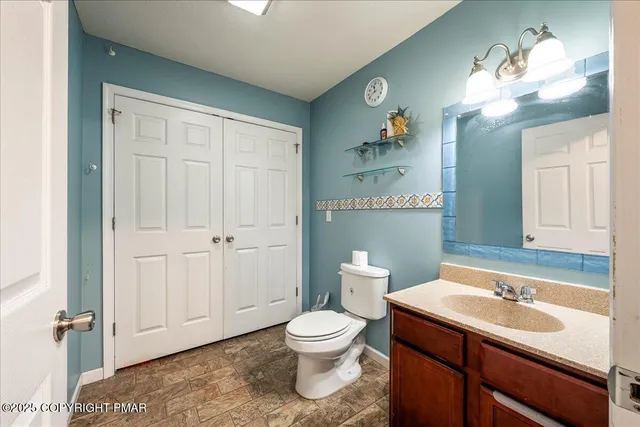 a bathroom with a toilet a sink and mirror