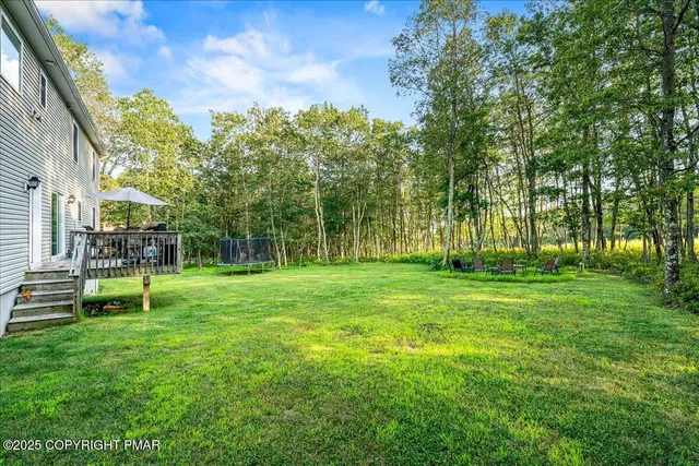 a view of house with a backyard