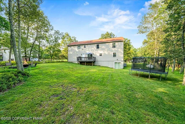 a view of a house with a big yard and large trees