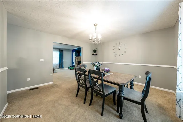 a view of a dining room with furniture and chandelier