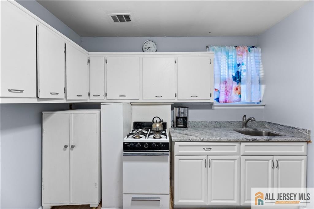 33 Prospect Lane Colonia, NJ 07067 - Photo 25 of 35 a kitchen with stainless steel appliances granite countertop a sink stove and cabinets