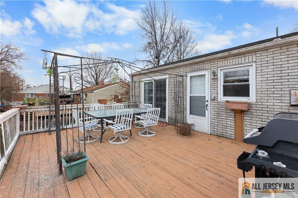 33 Prospect Lane Colonia, NJ 07067 - Photo 34 of 35 a view of a deck with table and chairs with wooden floor and fence