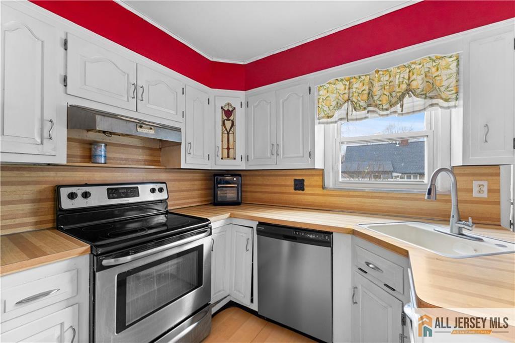 33 Prospect Lane Colonia, NJ 07067 - Photo 9 of 35 a kitchen with stainless steel appliances a sink a stove and white cabinets