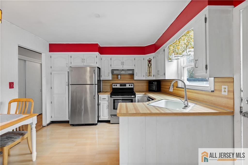 33 Prospect Lane Colonia, NJ 07067 - Photo 10 of 35 a kitchen with a refrigerator a stove a sink dishwasher and a microwave with wooden floor