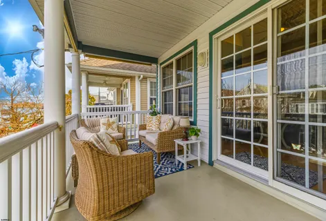 a balcony with furniture and next to a window