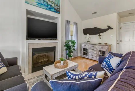 a living room with furniture a flat screen tv and a fireplace