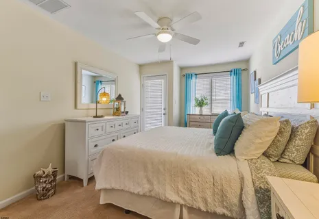 a spacious bedroom with a bed a dresser and a window