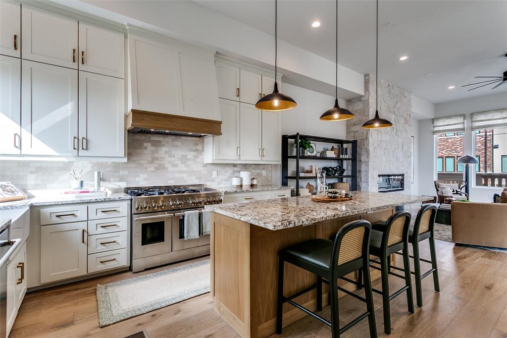 250 East Dallas Road, Unit 119 Grapevine, TX 76051 - Photo 19 of 40 a kitchen with stainless steel appliances granite countertop a stove a sink a refrigerator and chairs