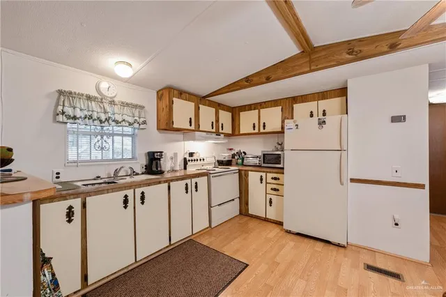 a kitchen with white cabinets and white appliances