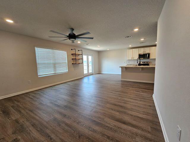 320 Flounder Street Crestview, FL 32539 - Photo 15 of 41 an empty room with wooden floor and a kitchen