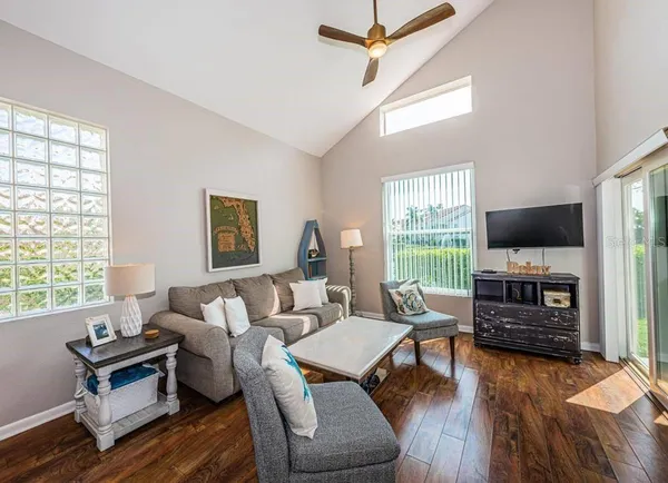 a living room with furniture flat screen tv and wooden floor