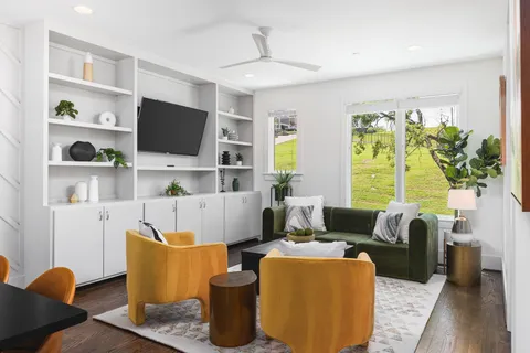 a living room with furniture a flat screen tv and large window