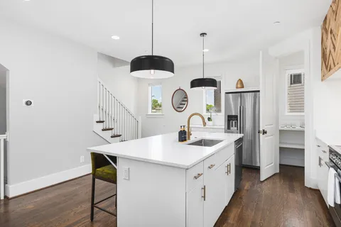 a kitchen with a sink a island a stove and a chandelier