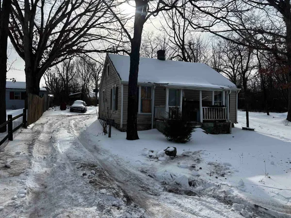 a view of a house with a yard covered in snow
