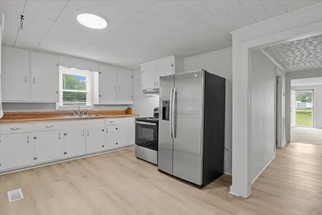 a kitchen with white cabinets and stainless steel appliances