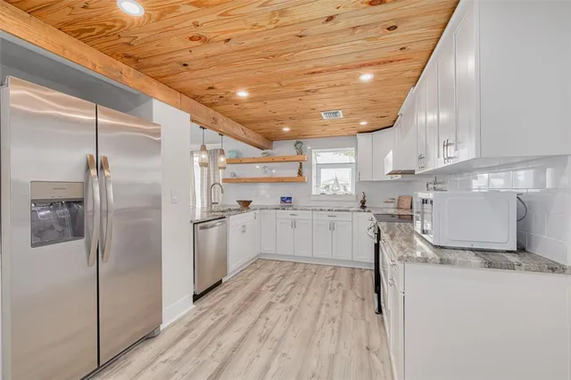a kitchen with refrigerator and cabinets