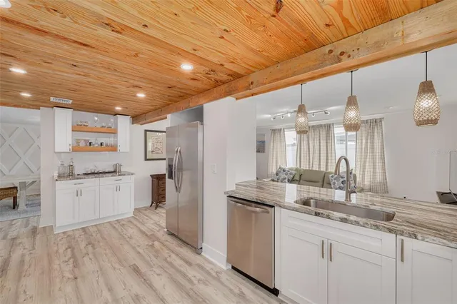 a large kitchen with a lot of counter space and wooden floor
