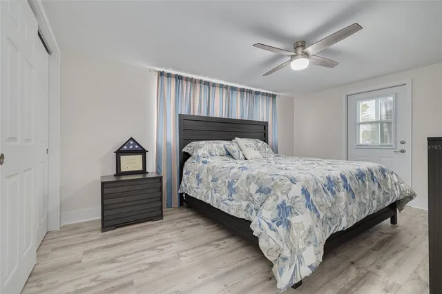 a bed sitting in a bedroom next to a window and a chandelier