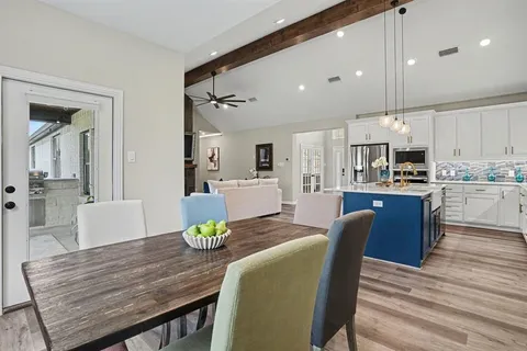 a large kitchen with kitchen island a island a sink a stove and a living room view