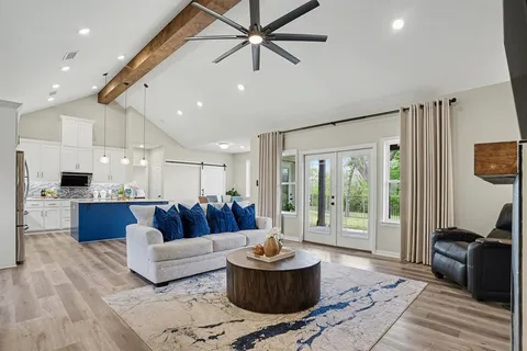 a kitchen with stainless steel appliances granite countertop a stove a dining table chairs and a refrigerator