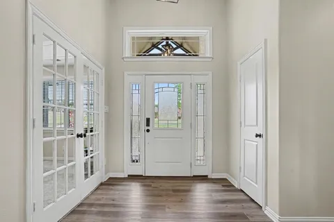 a view of a hallway with wooden floor and entryway
