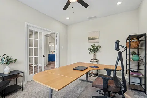 a room with chandelier fan and wooden floor