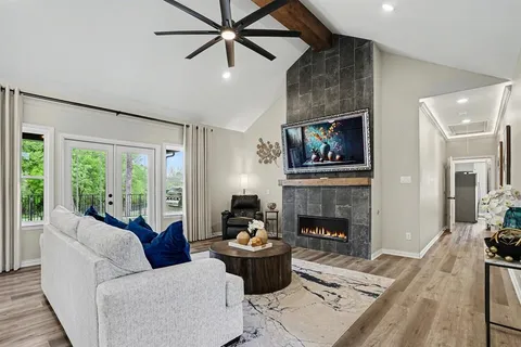 a living room with furniture fireplace and a large window